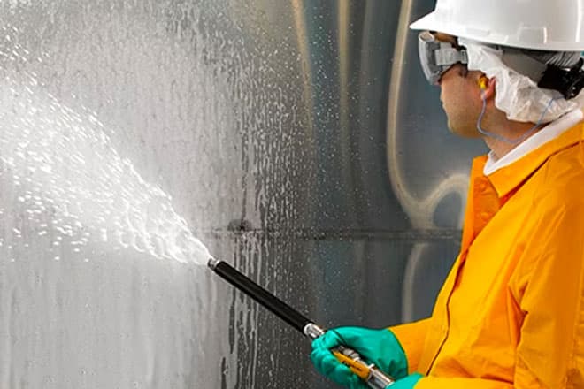 Operative pressure-washing the interior surface of a large water tank